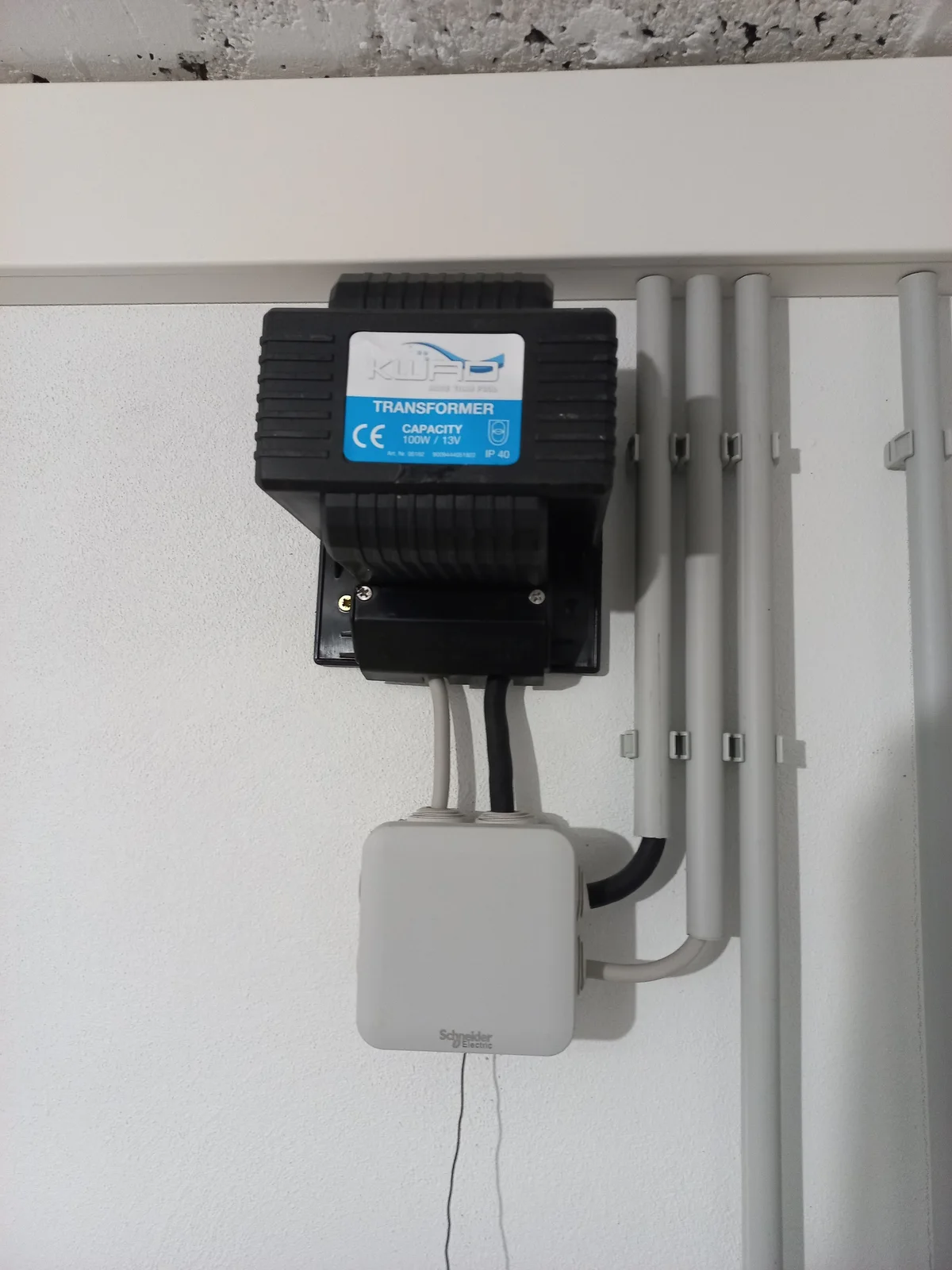 Wall-mounted swimming pool lighting transformer with conduit and electrical boxes